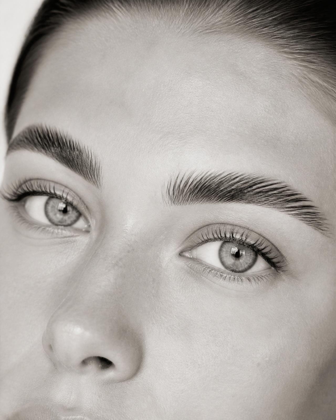 Editorial close-up of lifted natural lashes and laminated brows
